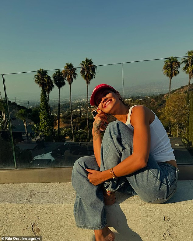 Among the snaps were several tanned selfies where Rita posed on a rooftop in a plain white T-shirt and blue jeans.