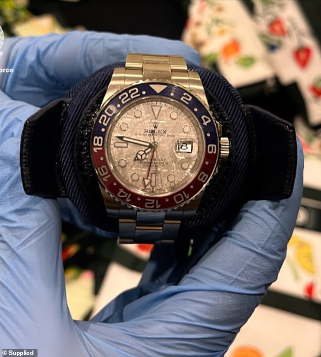 During the raids, police also seized ten cars, $800,000 in cash, a Rolex watch (pictured), four firearms, two bulletproof vests and multiple electronic devices.