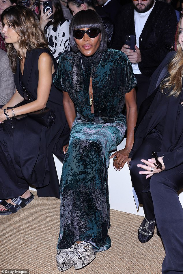 Naomi looked incredible in a green and black crushed velvet dress which she paired with statement sunglasses and snakeskin print shoes.