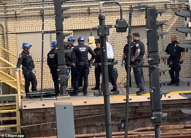 NYPD officers are seen surrounding a covered stretcher after Monday's tragic incident. The child has not been identified.