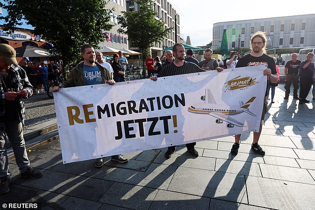 Far-right protesters hold a banner that reads 