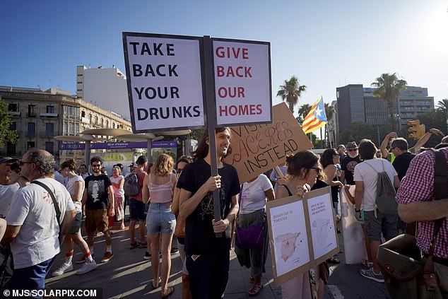 A protester holds a sign reading 'Give us back our drunks, give us back our houses' during a demonstration in Palma this month