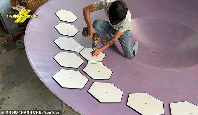 By layering fiberglass over the mold, builders create a plate-like shape. Ho then lays down a pattern of hexagonal boards to provide structure and mark the placement of future panels.