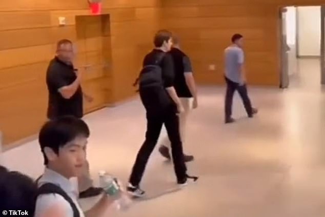 Clearly visible on video, his group of agents surround him throughout the hallways and lecture halls of New York University, a constant presence both several steps ahead of him and several steps behind.