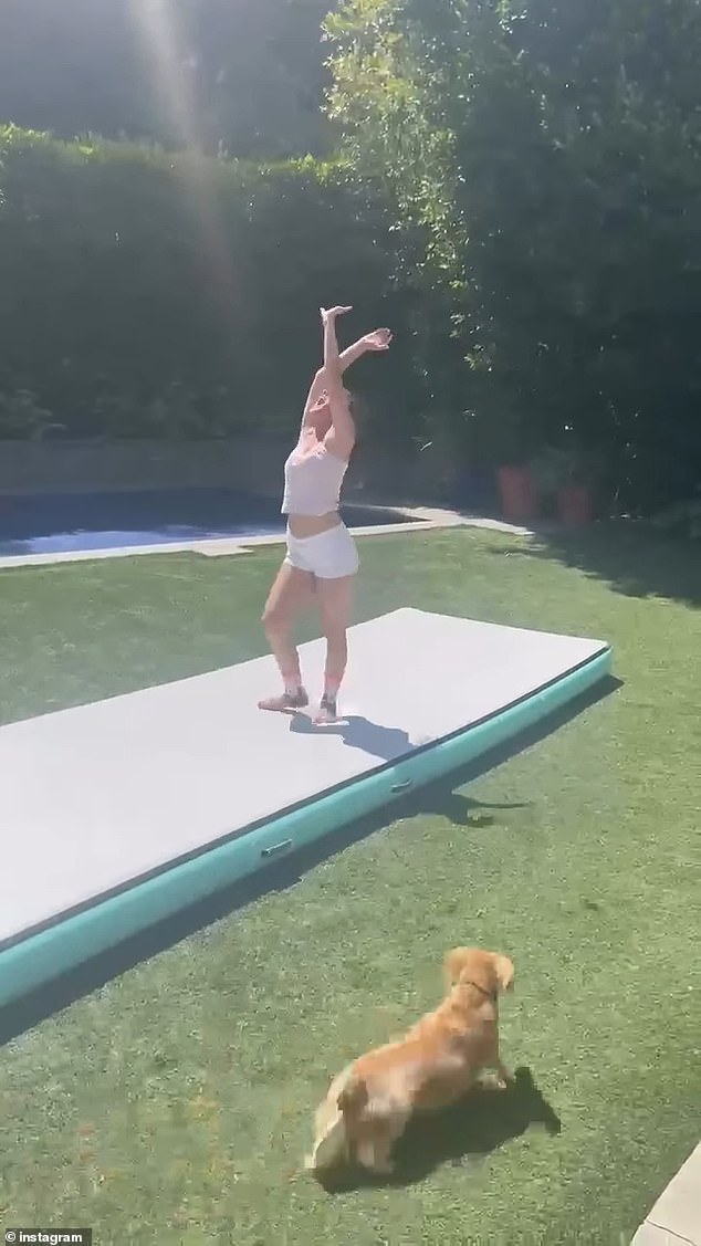 Charlotte, dressed in white shorts and a yellow tank top, is seen proudly performing a backflip for her mother.