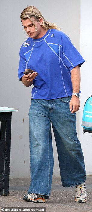 The AFL superstar was dressed in a blue shirt and baggy jeans and his signature blonde haircut was perfectly coiffed. He has played 103 AFL games since being drafted by the Bulldogs in 2018.