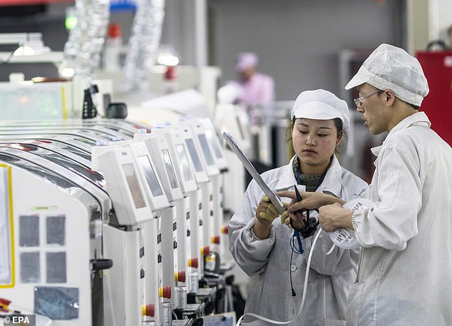 People work with machines at the Foxconn factory in Guiyang, Guizhou province, China, which produces technology for Apple and several other IT companies.