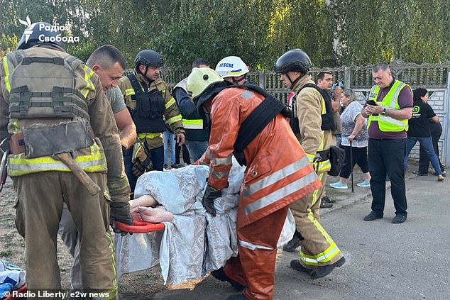 An elderly resident is carried out of the building on a stretcher, with 14 people injured in the explosion