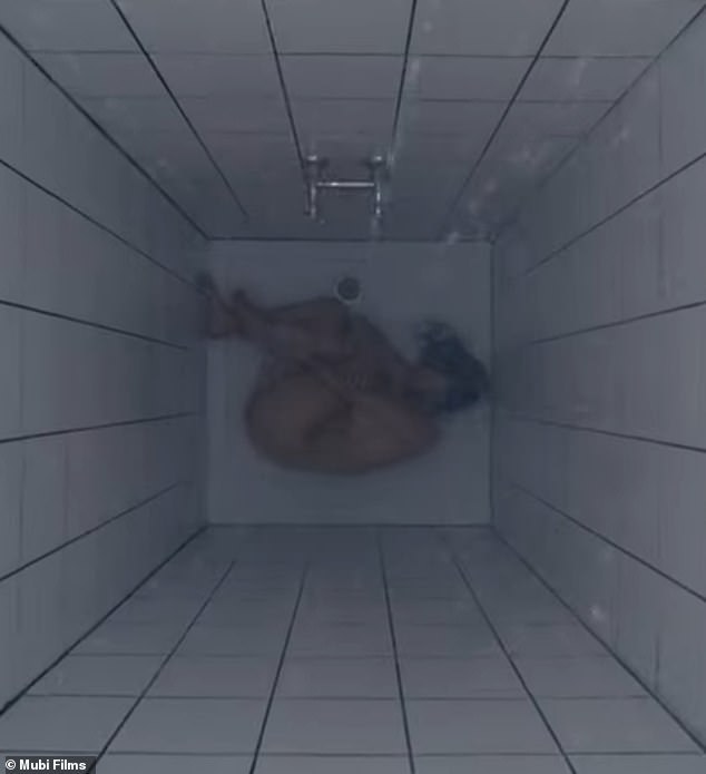 After taking the substance, Elisabeth Sparkle (played by Demi Moore) curls up into a ball in the shower.