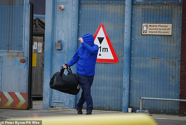 A person believed to be a prisoner hides his face as he leaves HMP Liverpool prison as 1,700 prisoners were released early under a government scheme to ease overcrowding.