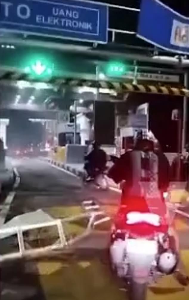 Shocked police officers stood at the destroyed toll gate as the truck sped away.