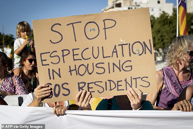 A protester holds a sign that reads: 