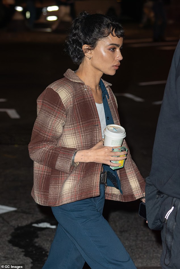 She was seen crossing the street, walking around the set with crew members, with a takeaway cup of coffee and a pack of cigarettes in one hand and her cell phone in the other.