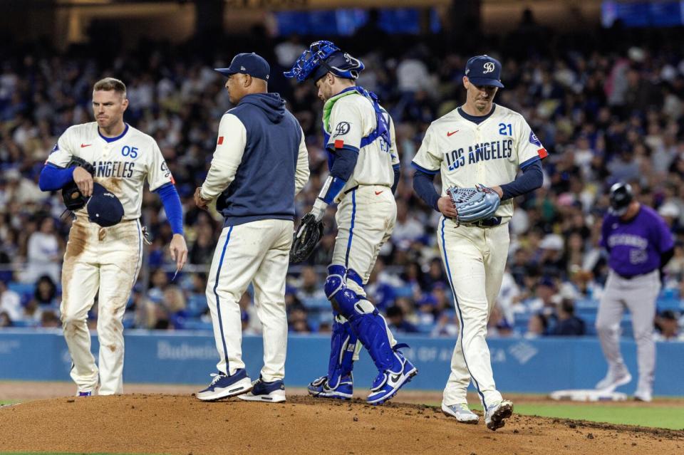 Dodgers manager Dave Roberts, second from left, removes starting pitcher Walker Buehler (21) from the game.