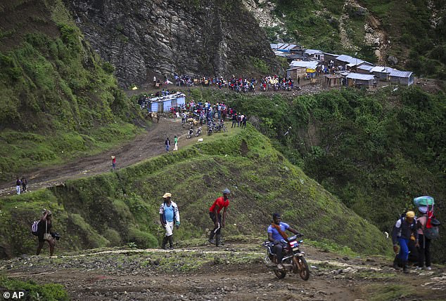 Crossing the land border between Haiti and the Dominican Republic is extremely risky, as travelers can face costly immigration fines and threats of kidnapping and violence, as the roads are where these cases are most likely to occur. Pictured: People walk through the mountains to avoid gang violence in the Kenscoff neighborhood in Port-au-Prince, Haiti, on September 10