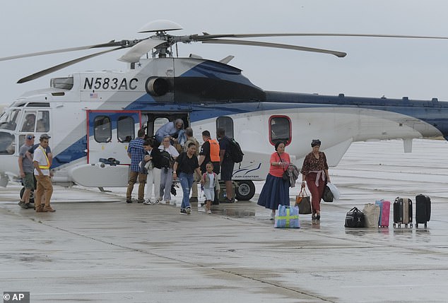 Toussaint Louverture International Airport in the commune of Port-au-Prince is a hotbed of carjackings and armed robberies, which often target lone drivers and women. Pictured: People evacuated from Haiti in a US helicopter arriving at Las Americas Airport in Santo Domingo, Dominican Republic, on March 22