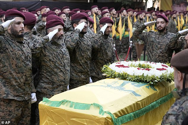 Hezbollah members salute near the coffin of Hezbollah commander Ibrahim Akil during the funeral procession in the southern suburb of Beirut