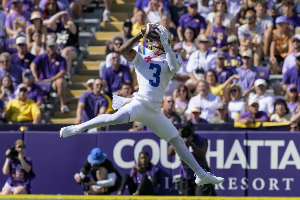 UCLA receiver Kwazi Gilmer leaps to catch the ball