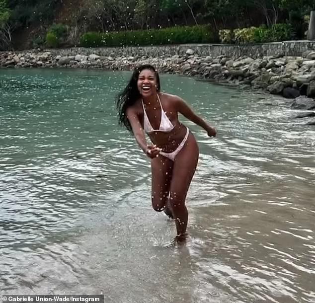 The raven-haired beauty shared clips of herself frolicking on the beach in a sexy floral bikini as she showed off her ageless beauty.