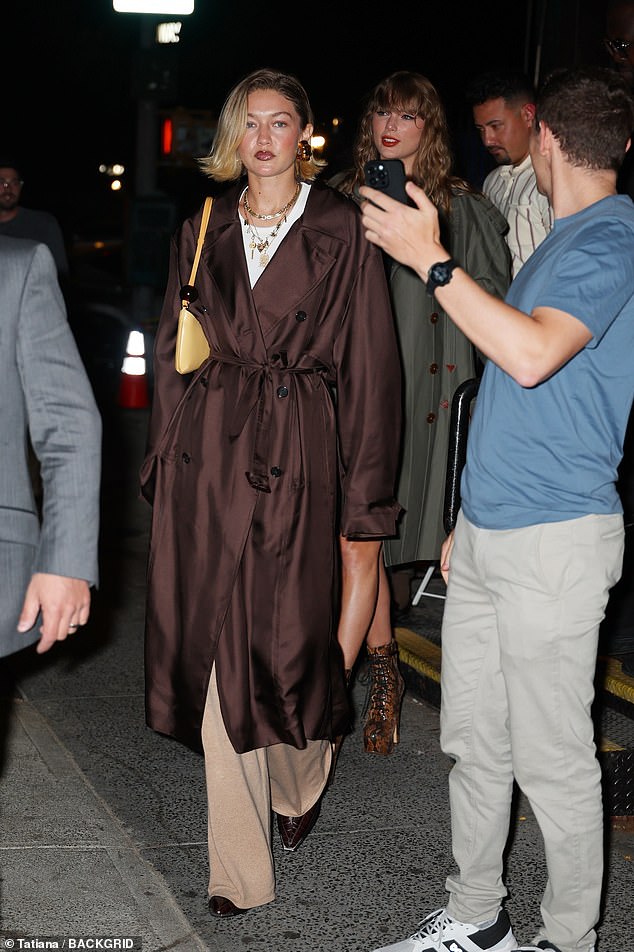 Taylor stunned her date at dinner in a brown and grey pleated tartan miniskirt, as well as a long-sleeved black crop top and a khaki green trench coat by Vivienne Westwood.