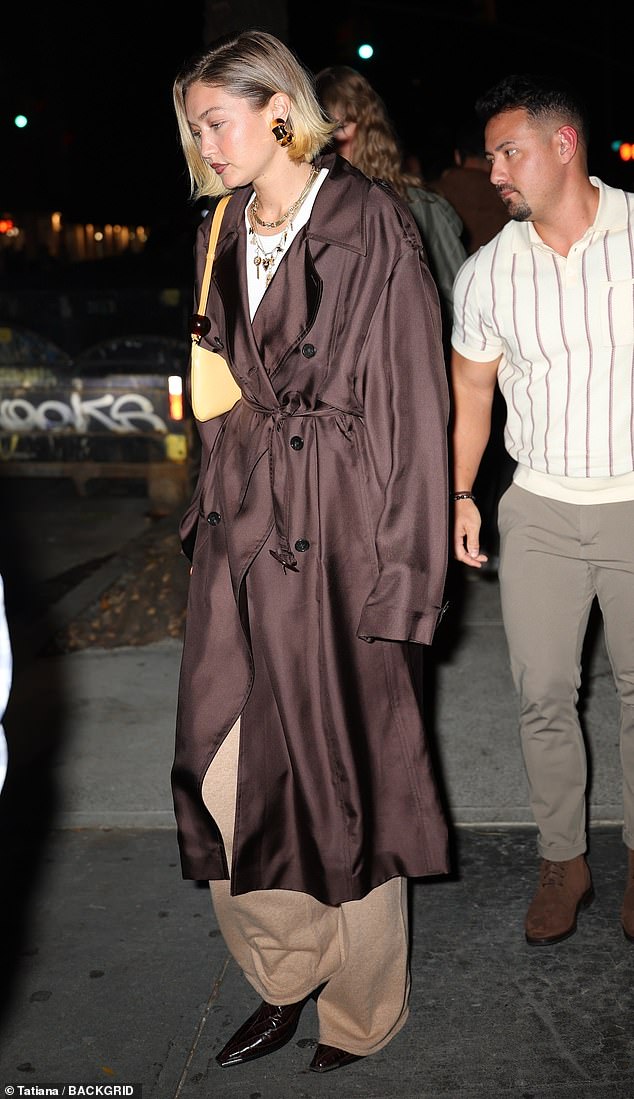 She accessorized her look with statement gold chain necklaces as well as chunky gold earrings and carried a small yellow handbag over her right shoulder.