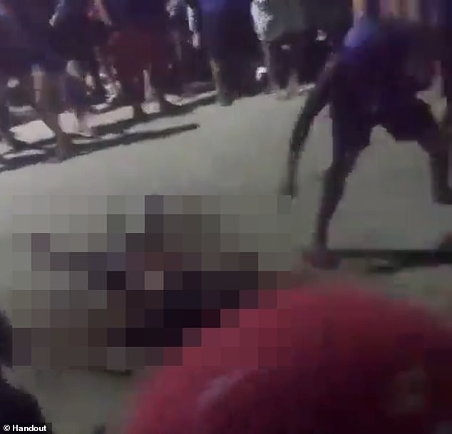 A resident approaches the body of Gregorio da Silva and sets it on fire after the 48-year-old was dragged out of a police station in Amazonas, Brazil, moments after allegedly confessing to the rape and murder of one-year-old Layla Vitória.