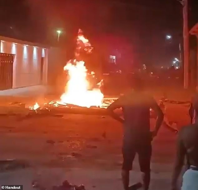 Residents of Jutaí stand near the burning body of Gregorio da Silva, who was set alight by an angry mob last Thursday night.