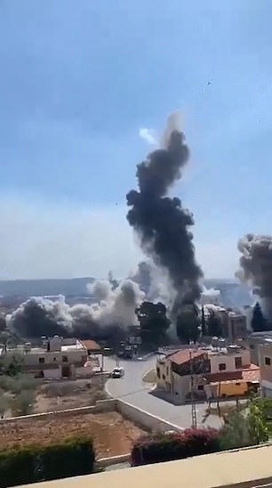 A person films from a rooftop in Lebanon as airstrikes approach their location