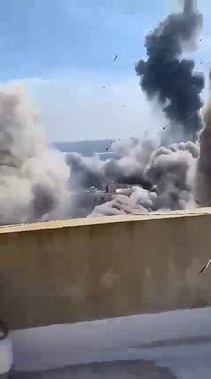 A person films from a rooftop in Lebanon as airstrikes approach their location