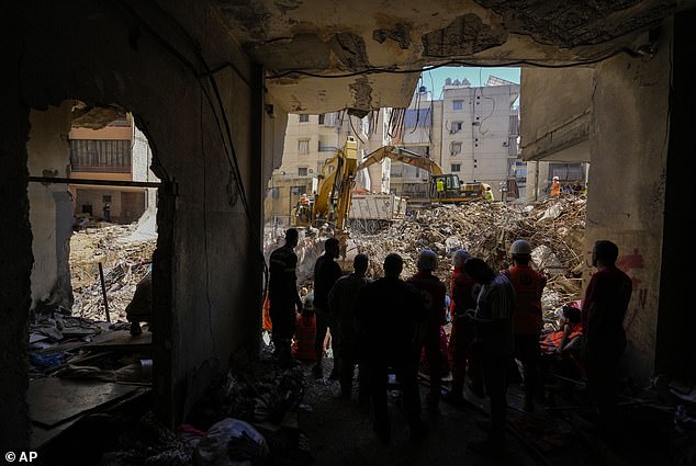 Emergency workers use bulldozers to clear debris at the site of Friday's Israeli attack in Beirut's southern suburbs.