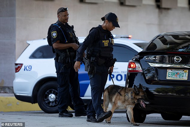 Law enforcement officers stand outside the Paul G. Rogers Federal Courthouse Building before the hearing for the trial of Ryan W. Routh