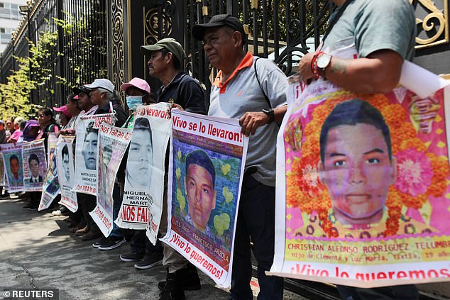 Relatives hold signs of the 43 students from a teacher training college who were killed by a gang of drug traffickers in Iguala, a city in the Pacific coast state of Guerrero, September 26, 2014. Parents and classmates have demanded justice from the administration of President Andres Manuel Lopez Obrador.