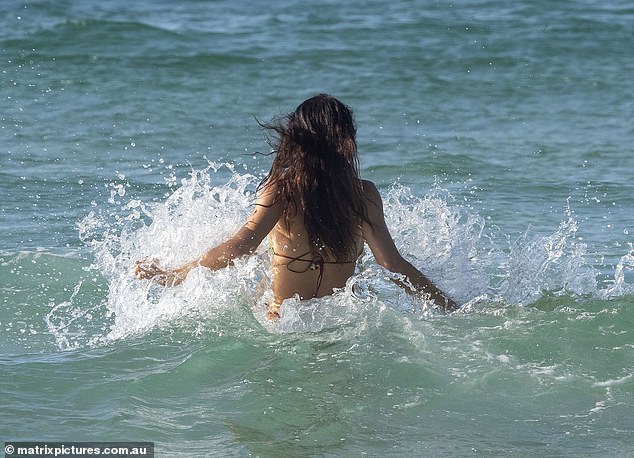 The stunning woman sweated profusely as she swam in the ocean and demonstrated how she keeps her body in tip-top condition.