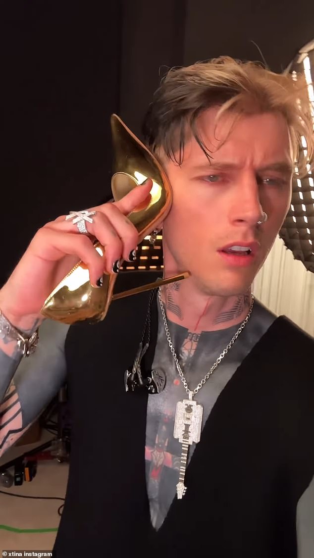 In the video, uploaded to her Instagram account, the singer can be seen filming herself sitting on a pink suede couch before panning the camera to Machine Gun Kelly, who is holding one of her high heels to his ear as if he were answering a phone.