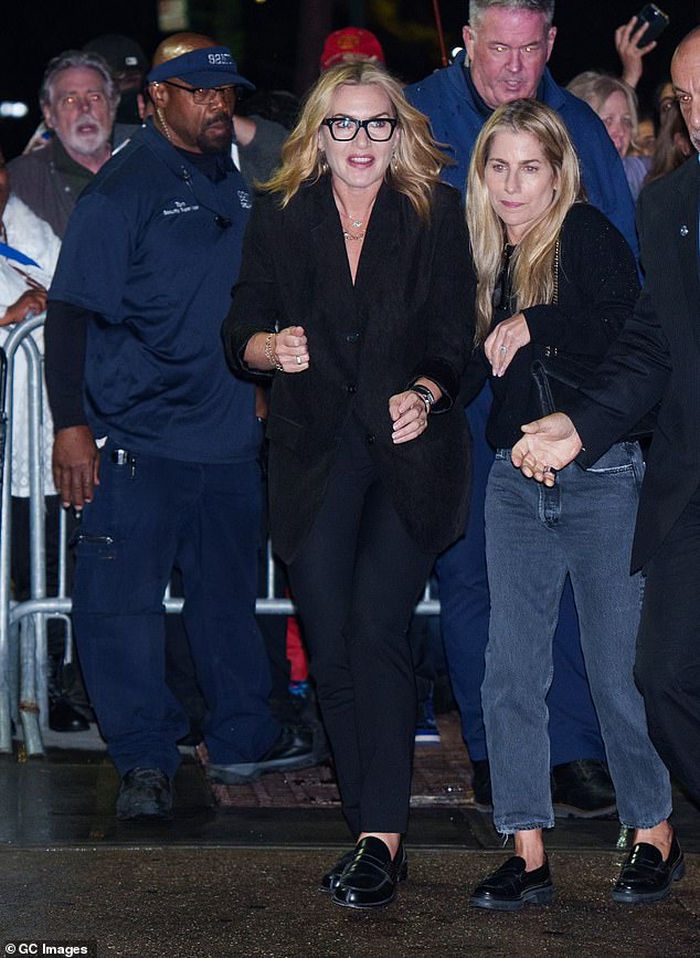 Kate complemented the oversized jacket with smart navy trousers and black loafers. She completed the look with black square-framed glasses and gold earrings.