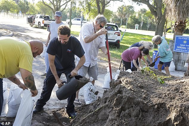 Residents in the Florida Panhandle, Big Bend region and the central and eastern Gulf Coast have been advised to stock up on food, gasoline, batteries and more. (Pictured: Residents in Tarpon Springs, Florida, are seen filling sandbags for the storm.)