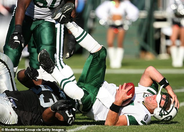 Favre, pictured playing for the New York Jets, clutches his head after hitting the turf in 2008