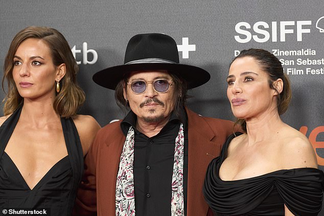 Depp walked the red carpet in a black shirt and a white scarf draped over his shoulders.