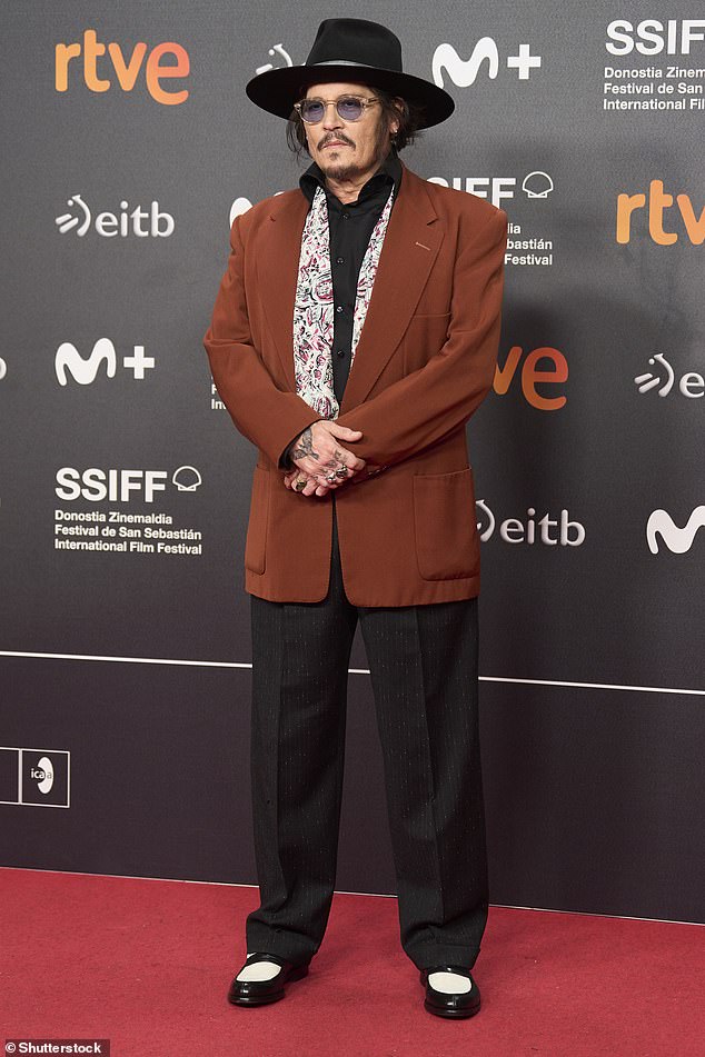 The actor completed his look with a burnt red suit jacket, black pants and black and white dress shoes.