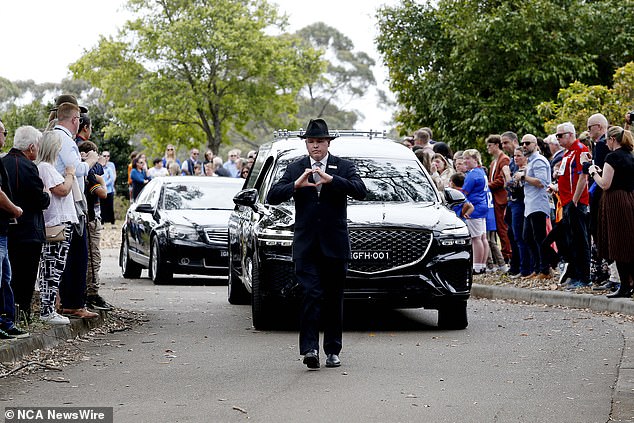 Mourners lined the driveway as the hearse drove past during the funeral in Springwood