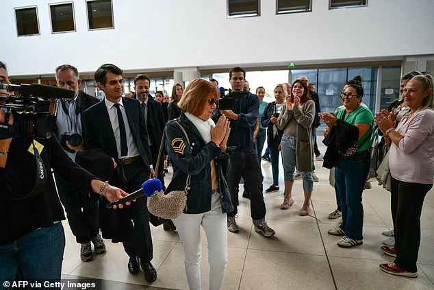 Gisele Pelicot (C) acknowledges the applause of the public upon her arrival at the Avignon courthouse during the trial.