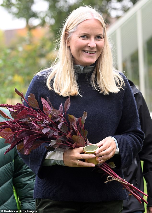 Mette-Marit, whose son Marius is currently the subject of intense scrutiny in the Norwegian press, smiled as she held a bouquet of flowers.