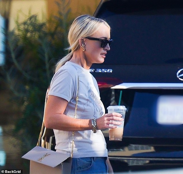 She cut her best figure in a simple white blouse paired with jeans as she walked down the picturesque street of the upmarket Los Angeles suburb.