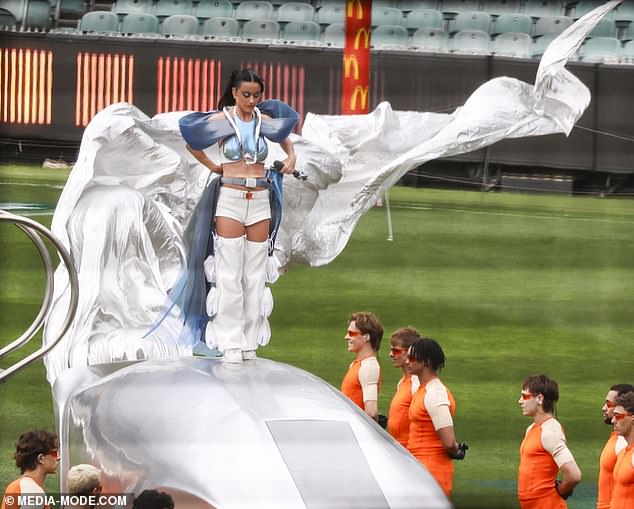 With her sleek high ponytail and matching bold blue eyeshadow, Katy fully embraces the avant-garde aesthetic, ensuring all eyes are on her as she prepares to dazzle the crowd.