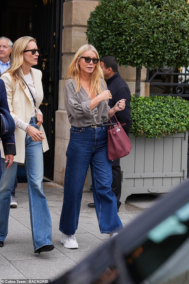 The Goop founder paired her look with black tones and opted for comfort on her feet with white sneakers.