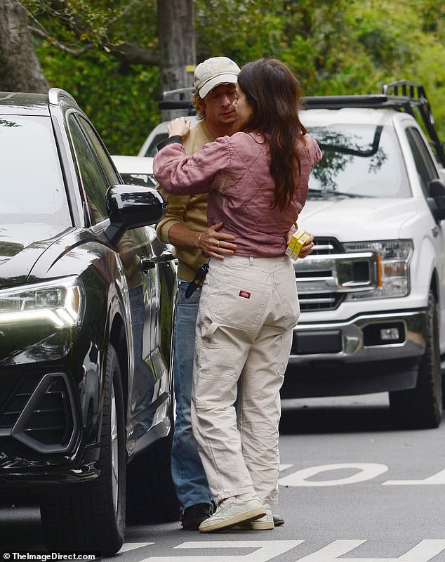 Jeremy looked smitten with his co-star as they cuddled up next to his car.