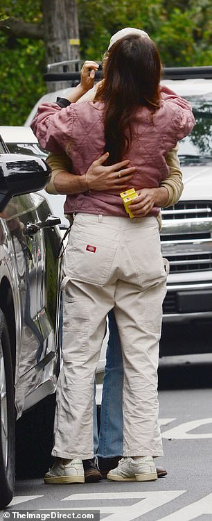 The new couple looked in love as they hugged each other next to the car.