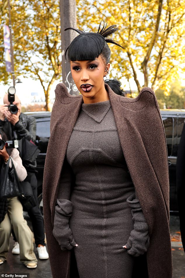 The rapper showed off her curves in a fitted gray knit dress as she arrived at the glitzy fashion event, after welcoming her third child, a baby girl, just 19 days ago.