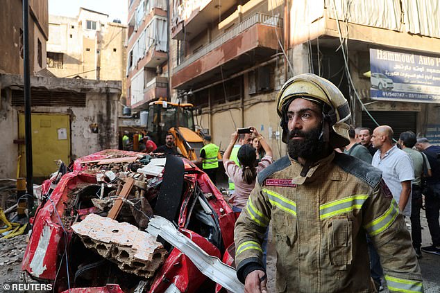 A firefighter at the scene of an Israeli attack, in the southern suburbs of Beirut,