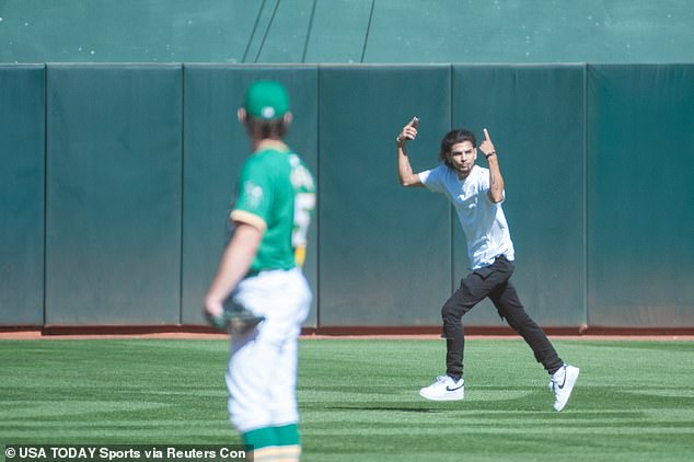 A fan runs onto the field during the ninth inning of the A's final game in Oakland.